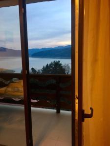 an open door to a balcony with a view of the water at Pensiunea Lostrita in Buhalniţa