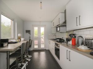a kitchen with white cabinets and a counter top at Blantyre Cottage in Muir of Ord