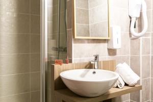 y baño con lavabo blanco y ducha. en Hôtel du Pont, en Ascain