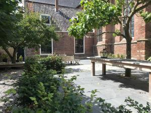 a park bench in front of a brick building at Bed en kerk monumentale 2 slaapkamer woning in Hoorn