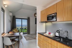 une cuisine avec un évier et une table avec des chaises dans l'établissement OurMadeira - Quinta Inácia, countryside escape, à Calheta