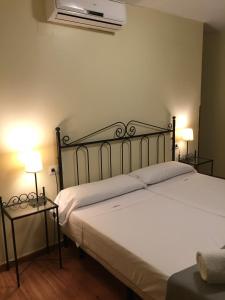 Cama en habitación con 2 lámparas y cama sidx sidx sidx sidx en Hospedería Luis de Góngora, en Córdoba