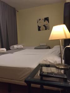 een kamer met een bed en een tafel met een lamp bij Hospedería Luis de Góngora in Córdoba