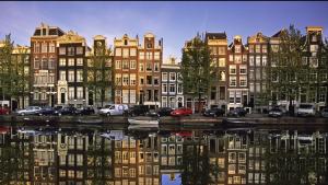 um grupo de edifícios ao lado de uma massa de água em B&B Diemerplein em Amsterdã