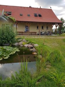 ミコワイキにあるEko Zagroda Bocianie Gniazdoの池のある家