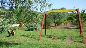 an empty swing set in a field of grass at Agriturismo Isidoro in Fertilia