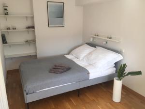 a small bedroom with a bed with white walls at Fregata Apartment Gdynia in Gdynia