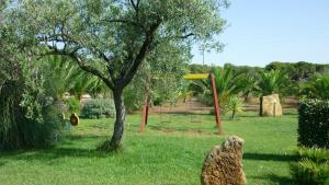 a playground with a tree and a yellow frisbee at Agriturismo Isidoro in Fertilia