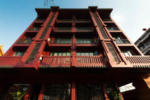 a tall red building with balconies at Casa Nithra Bangkok in Bangkok