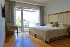 a bedroom with a bed and a sliding glass door at Sunrise Pearl Hotel & Spa in Protaras