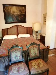 1 dormitorio con 1 cama y 2 sillas en Mugello - casa di campagna, en Vicchio