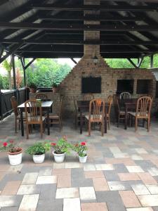 un patio con mesa, sillas y chimenea en Kerekes Panzió és Étterem, en Balmazújváros