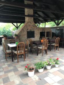 a patio with tables and chairs and a brick fireplace at Kerekes Panzió és Étterem in Balmazújváros