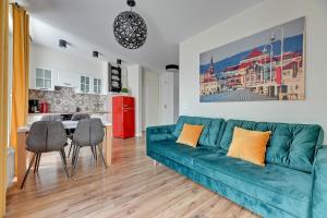 un soggiorno con divano blu e una cucina di Comfort Apartments Dolny Sopot a Sopot
