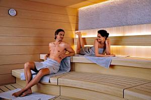 mężczyzna i kobieta siedzący w saunie w obiekcie Ferienwohnung Dimpfl-Stad´l Fam. Lemberger w mieście Lohberg