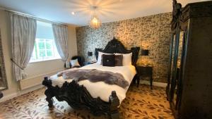 Un dormitorio con una cama grande y una lámpara de araña. en The Sea Trout Inn, en Totnes