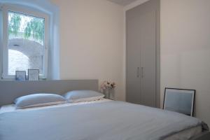 een slaapkamer met een groot wit bed en een raam bij Apartmani Stones Sutivan I in Sutivan