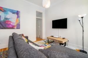 ein Wohnzimmer mit einem Sofa und einem Flachbild-TV in der Unterkunft WHome | Prime Location Design Family Apartment in Lissabon