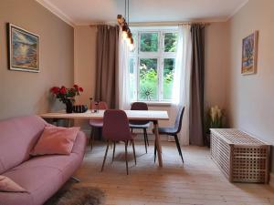 ein Wohnzimmer mit einem rosa Sofa und einem Tisch in der Unterkunft BoWell apartments with terrace i Rønne in Rønne