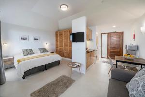 une chambre avec un lit et un salon dans l'établissement OurMadeira - Quinta Inácia, countryside escape, à Calheta