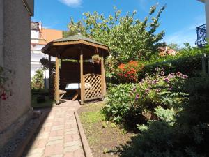 a wooden gazebo in the middle of a garden at U Grażyny in Kołobrzeg