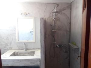 a bathroom with a sink and a shower at ThalaSEA Apartments in Chrani