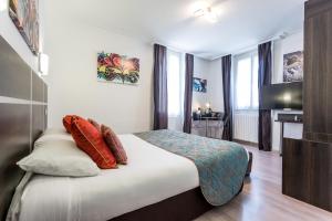 a hotel room with a bed and a desk at Hotel Le Centre in Gramat