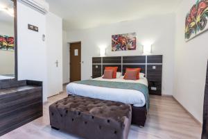 a bedroom with a large bed and a couch at Hotel Le Centre in Gramat