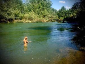 a woman standing in the water in a river at "Pivnica i smestaj Jovanovic"- Rogljevacke pivnice in Rogljevo