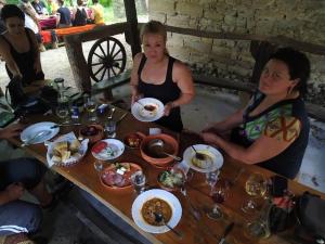 two women sitting at a table with plates of food at "Pivnica i smestaj Jovanovic"- Rogljevacke pivnice in Rogljevo