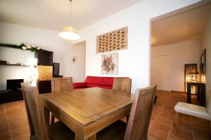 jadalnia z drewnianym stołem i czerwoną kanapą w obiekcie Il Baio Relais & Natural Spa w mieście Camporoppolo +23 zdjęcia