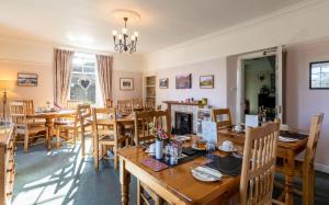 a dining room with wooden tables and chairs at Elterwater Park Farmhouse Bed and Breakfast in Elterwater