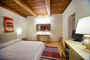una camera con letto, scrivania e specchio di Il Baio Relais & Natural Spa a Camporoppolo
