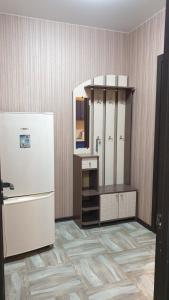 サマラにあるApartament na Novo-Sadovoi 106litOの冷蔵庫と鏡付きの部屋