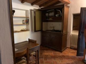 een keuken met een tafel en een houten kast bij B&B La Loccaia in Ciggiano