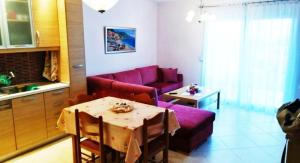 クリオピギにあるEmerald Apartment with Sea Viewのリビングルーム(テーブル、紫色のソファ付)