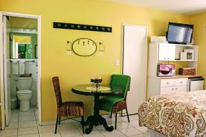 a bedroom with a table and a bed and a clock on the wall at Villa Venezia in Fort Lauderdale
