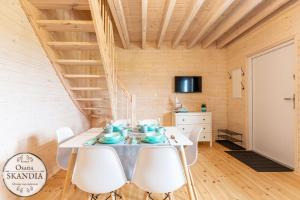 a dining room with a white table and white chairs at Osada Skandia Kopań in Kopań