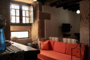 a living room with a red couch and a window at Casa do Balcão in Alcains