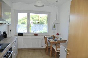 une cuisine avec une table à manger et une fenêtre dans l'établissement Rothaarsteig Ferienhaus, à Kirchhundem