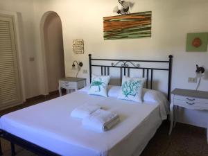 a bedroom with a large bed with white sheets and pillows at Roda' in Panarea