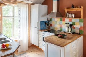uma cozinha com um frigorífico branco e um balcão em Sustainable and soulful close to lake em Gnesta