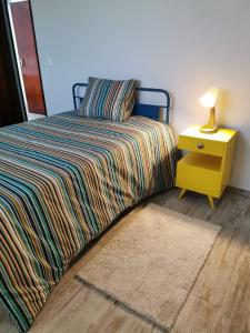 a bedroom with a bed and a nightstand with a lamp at A PRAIA - MY OWN PARADISE Piso Térreo in Praia de Quiaios