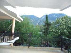 een balkon met uitzicht op bomen en bergen bij Ενοικιαζόμενα δωμάτια "ΟΛΓΑ" in Loutra Ipatis