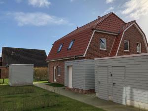 カロリーネンジールにあるFerienhaus Muschelpadd 3dの赤屋根の家