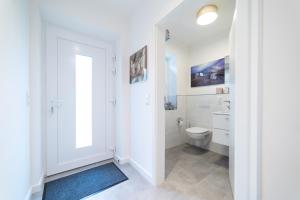 カロリーネンジールにあるFerienhaus Muschelpadd 3dのトイレと洗面台を備えた白いバスルーム +17枚の写真