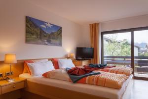 a bedroom with two beds and a large window at Hotel Müggelturm in Oberstdorf