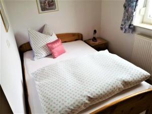 a small bedroom with a bed with pillows on it at Ferienwohnung Gerti in Mauth