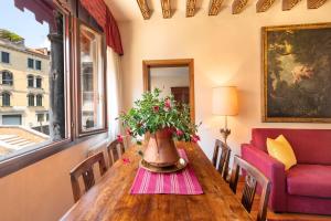 a dining room table with a vase of flowers on it at Palazzo Schiavoni Suite-Apartments in Venice