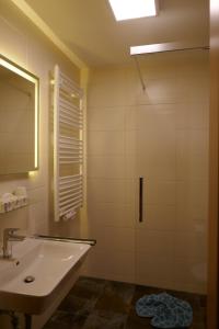 a bathroom with a sink and a mirror at Hotel Müggelturm in Oberstdorf